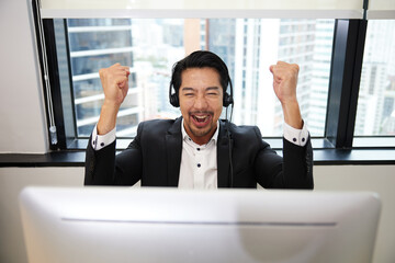 operator wearing headphones and celebrating successful after finish work at call center service