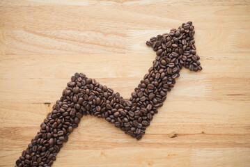 Coffee roast arabica bean as graph chart soar rising up on wooden background. Coffee bean price...