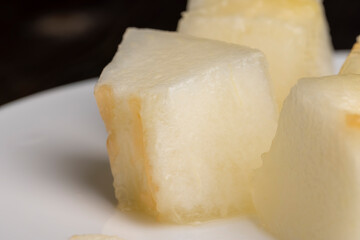 Ripe yellow melon cut into pieces and portions