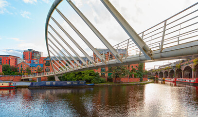 Amazing rainbow over the waterway canal area with a narrowboat on the foreground modern bridge, Castlefield district - Manchester, UK © muratart