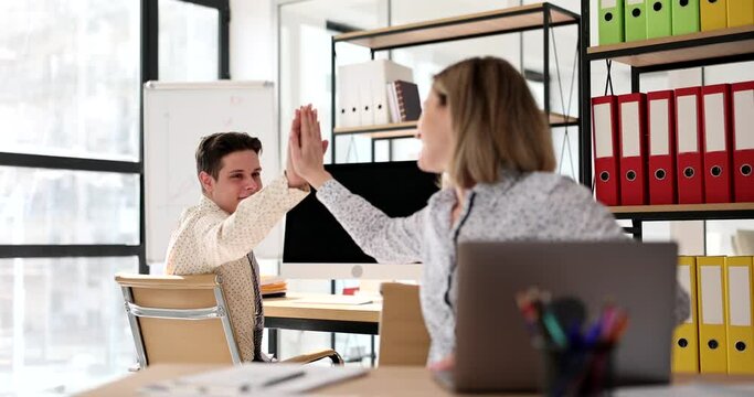Successful business partners high five in office