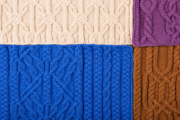 Knitted beige, lilac, brown and blue background. Large knitted fabric with a pattern. Close-up of a knitted blanket.