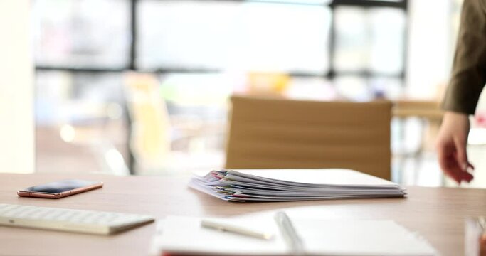 Woman tosses stack of business documents onto table
