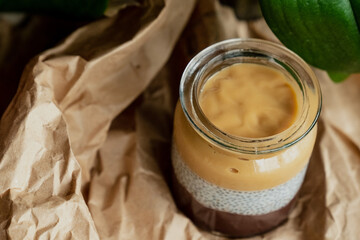 Homemade pudding with granola, kiwi, grapes, coconut, flower leaf background