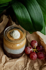 Homemade pudding with granola, kiwi, grapes, coconut, flower leaf background