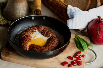 Turkish breakfast, scrambled eggs in a simit bun in a frying pan, coffee in a Turk, fresh bread