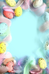 Easter background with feathers and eggs on blue background. Flat lay. Happy easter day.