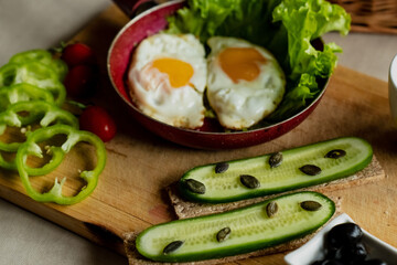 classic breakfast, scrambled eggs, simit bun, fresh vegetables, cucumber