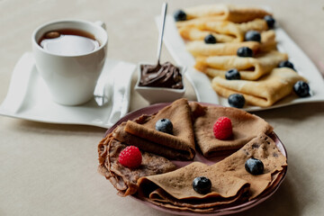 classic and chocolate pancakes with berries and fruits for breakfast, chocolate, tea,