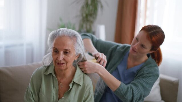 Nurse combing her senior client at home.