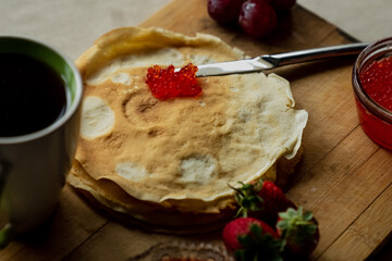 Pancake with red caviar for breakfast, a cup of tea