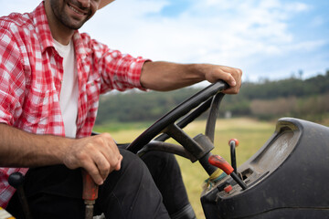 Portrait of young  adult Caucasian man farmer sitting in tractor smiling to work. Field farming vehicle. Machine for agriculture.