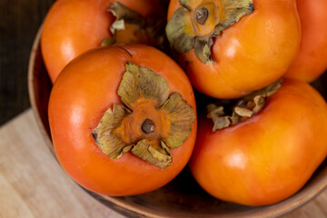 Whole ripe orange persimmon on the table