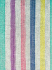 The texture of the fabric. White sheet in multi-colored lines. Cotton, linen, calico. Striped background.