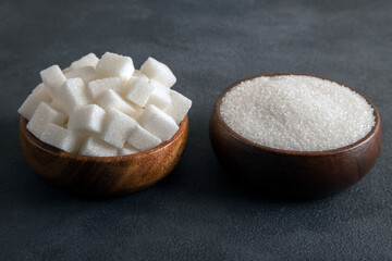 Fototapeta na wymiar Cube sugar and granulated sugar on black background