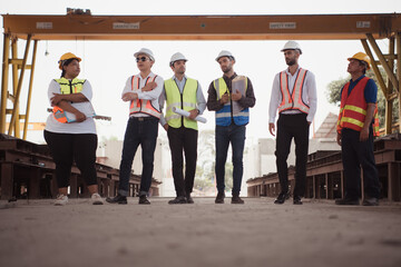 Group of architects, construction foremen, and construction engineers review the work and talk about how the project, in the construction site.