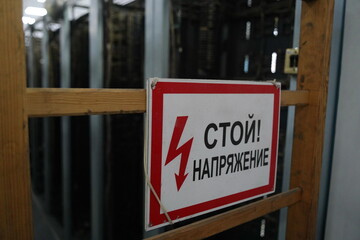 Almaty, Kazakhstan - 10.07.2022 : Russian signboard with the inscription: Stop, tension. Power plant.