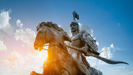 Statue of the hero Manas representing the epic of Manas against the background of the sky of...