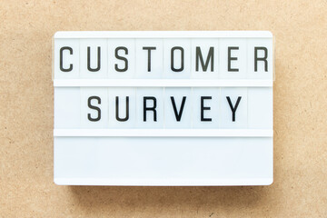 Lightbox with word customer survey on wood background