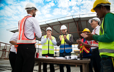 Construction engineers, architects, and foremen form a group. Participate in a meeting to plan new construction projects. Cheers to express happiness that the event was successfully accomplished.