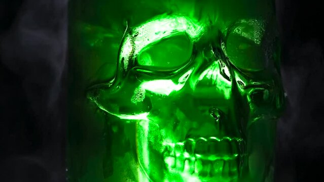 Glass Rotating Skull. Green glass skull slowly rotates on a black background in a couple of clubs