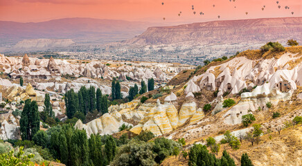 The Pigeon Valley in Cappadocia is captured in all its beauty, with colorful hot air balloons dotting the horizon in the distance.