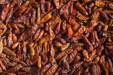 Close up on an overhead view of scattered cayenne chili peppers. Organic texture abstract background.