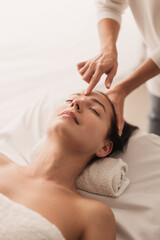 Fototapeta na wymiar Acupuncturist pressing point on forehead of woman