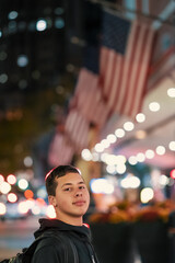 child in the city at night with American flags in the background
