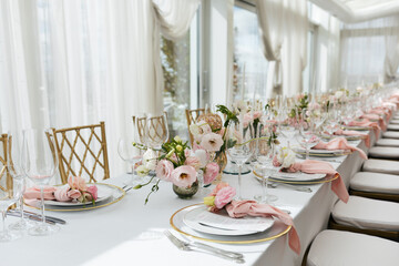 Wedding decorations. Served wedding table with decorative fresh pink flowers and candles....