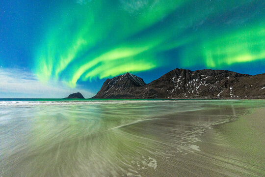 Waves crashing on frozen Haukland Beach under the Northern Lights (Aurora Borealis), Leknes, Nordland county, Lofoten Islands, Norway, Scandinavia, Europe