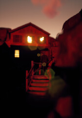 Man stands on wooden staircase in an old mountain village during sunset. 3D render.