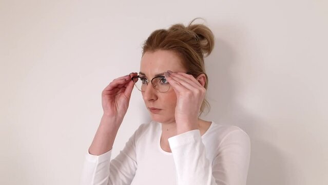 Beautiful woman putting on glasses. Eyesight, vision concepts