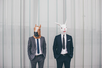 Two unidentified businesspeople elegant and professional wearing a horse and a rabbit mask