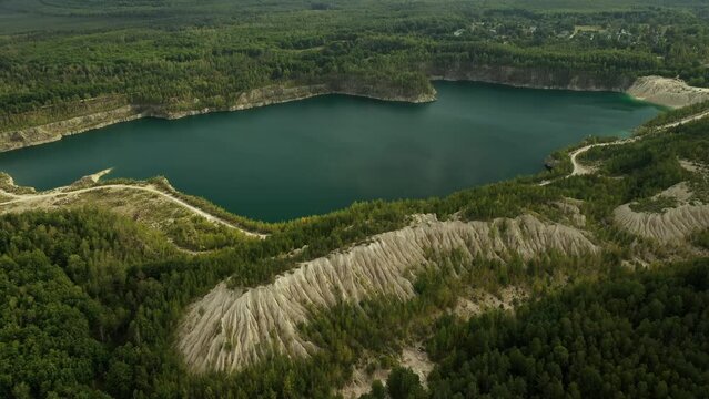 A very beautiful lake among the hills, quartz mountains and the endless Ukrainian forest. Bright, sunny day. Druzhbovsky quarry, Zhytomyr region, Ukraine.
