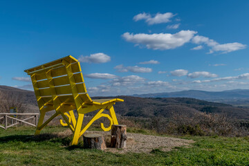 A giant yellow bench with a panoramic view of the surrounding nature, Castiglion Fibocchi, Arezzo,...