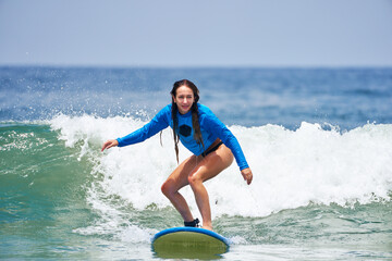 young caucasian brazilian beginner woman surfing the wave in Brazil
