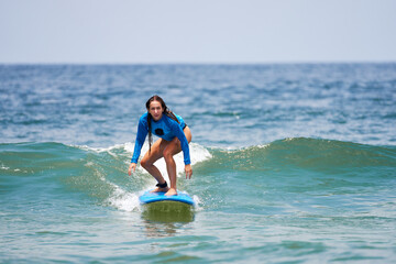 young caucasian brazilian beginner woman surfing the wave in Brazil
