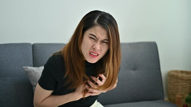 Asian woman having heart attack problem. A heart attack occurs when an artery that sends blood and oxygen to the heart is blocked.
