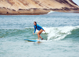 young caucasian brazilian woman beginner surfer surfing  the waves in Brazil	