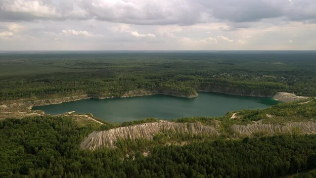 A very beautiful lake among the hills, quartz mountains and the endless Ukrainian forest. Bright, sunny day. Druzhbovsky quarry, Zhytomyr region, Ukraine.
