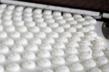 Production. White marshmallow moves along the conveyor