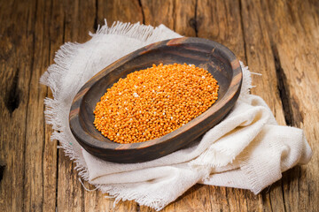 red millet grains in container, healthy cereal, close-up image