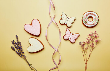 Aesthetics spring cookies among lavender. Spring card top view. Baked glazed symbols of Easter on yellow background.
