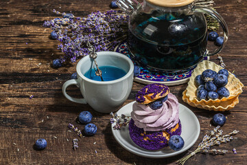 The concept of romantic tea. French Shu cake, Lavender tea, blueberries, festive decor