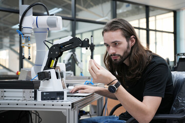 Man working at industrial robot in modern factory