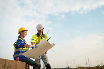 Female engineer at wind farm with plans
