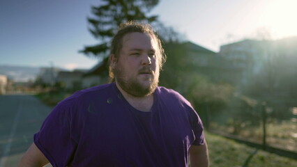 One pensive young overweight man walking outdoors. Thoughtful expression of a fat person in street....
