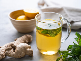 Herbal tea with fresh lemon, mint and ginger on a light background. The concept of a healthy drink