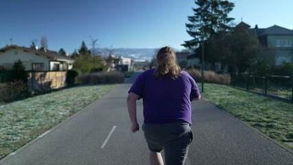 Back of one determined fat man to lose weight and get back into shape. Motivational concept of overweight person running outdoors